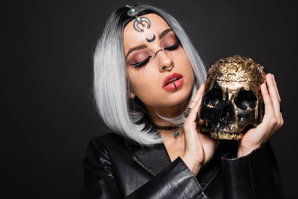 seductive ash blonde woman with halloween makeup and creepy skull isolated on black - Zdjęcie, obraz