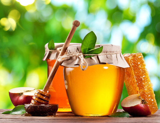 Glass cans full of honey and apples. - Φωτογραφία, εικόνα