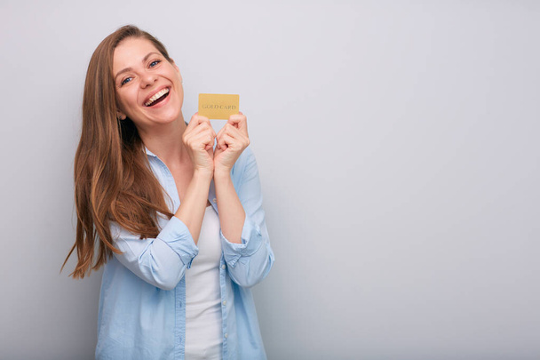Luottokortti kädessä onnellinen naurava nainen pitkät hiukset pukeutunut sininen valkoinen paita eristetty muotokuva   - Valokuva, kuva