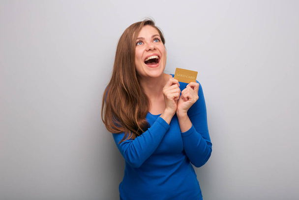 Happy woman with mouth open holding credit card looking up isolated female portrait. - Photo, image