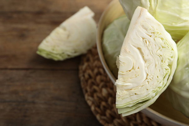 Fresh ripe cabbages in bowl on wooden table, closeup. Space for text - 写真・画像