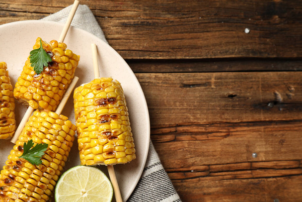 Tasty grilled corn on wooden table, top view. Space for text - Photo, Image