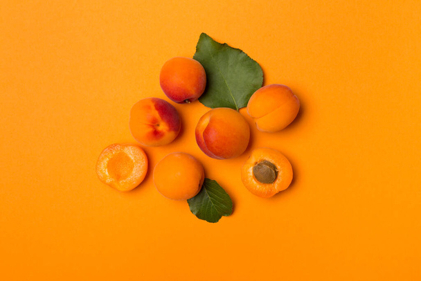 Flat lay with ripe apricots on color background, top view. - Foto, imagen