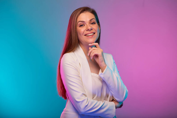 Thinking business woman touching her face, portrait with neon lights colors effect. Female model on neon colored background wearing white suit. - Fotografie, Obrázek