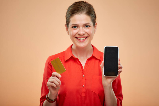 Isolated portrait of smiling business woman holding credit card and smartphone. - Foto, Bild