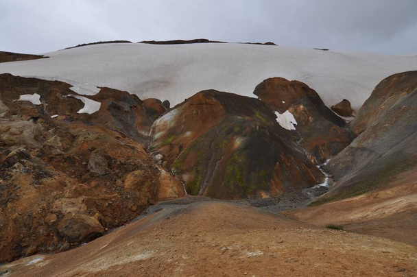 Kerlingarfjoll es una cadena montañosa en Islandia situada en las Tierras Altas de Islandia, cerca de la carretera de las tierras altas de Kjolur. El origen volcánico de estas montañas se evidencia por las numerosas aguas termales y arroyos de la zona, así como el riol volcánico rojo - Foto, imagen