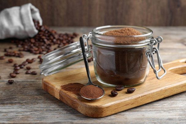 Glass jar of instant coffee and spoon on wooden table - Foto, imagen