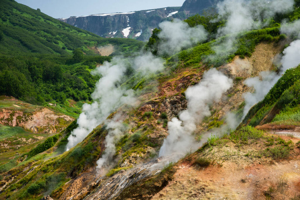 живописные горы с активными кратерами, извергающимися газовым дымом  - Фото, изображение