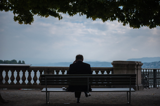 Mann sitzt am Zürichsee - Foto, Bild