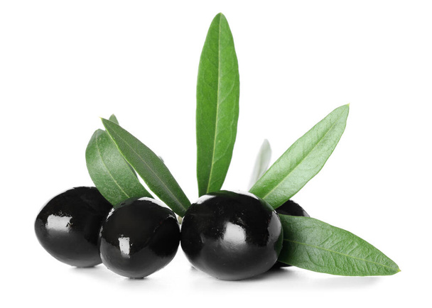 Delicious black olives with leaves on white background - Foto, Imagem