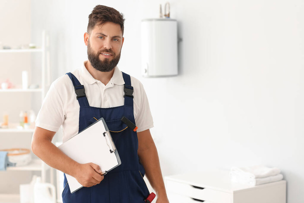 Male plumber with clipboard in bathroom - Photo, Image