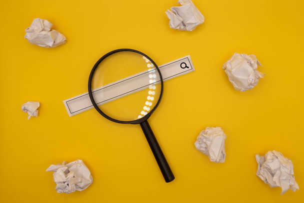 magnifying glass, web search tape and crumpled papers yellow background - Foto, Imagem