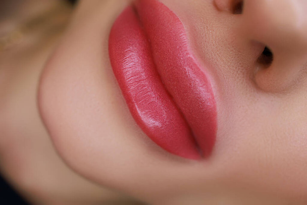 close-up of the lips of a girl model on which permanent lip makeup is performed - Fotó, kép