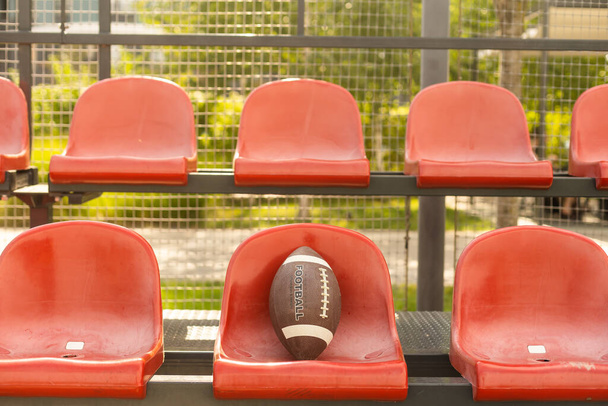 American football ball on the tribune of the stadium. - Foto, Bild