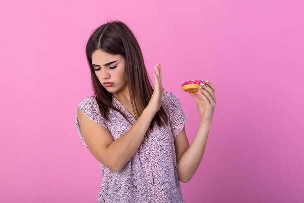 Woman on dieting for good health concept. Close up female using hand push out her favourite donut for good health. Diet, dieting concept. Junk food, Slimming, weight loss - Foto, Bild