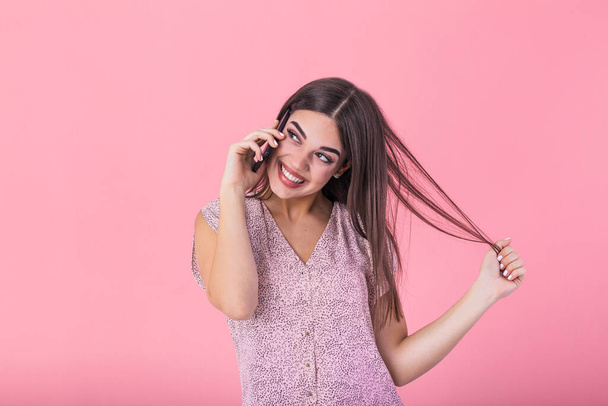 Beautiful teen woman talking on cellphone, making happy surprice face, studio shot. Portrait of a pretty joyful girl in dress talking on mobile phone - Foto, Imagen