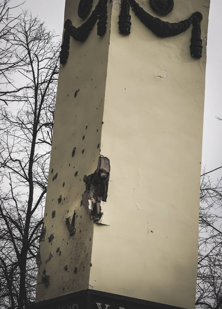 Shrapnel marks on the architectural structure "Kharkiv Gate" after an artillery attack in Ukraine during armed hostilities and aggression - Foto, imagen