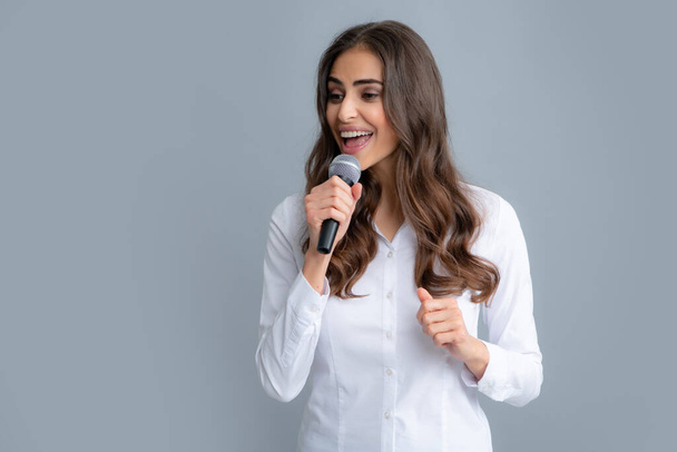 Woman speech, business woman holding a microphone. Portrait of young woman journalist in casual shirt holding microphone, asking questions, discussing problems, interviewing - Foto, Imagem