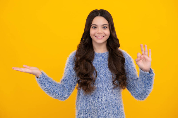 Close-up portrait of her she nice cute attractive cheerful amazed girl pointing aside on copy space isolated on yellow background. Happy teenager, positive and smiling emotions of teen girl - Photo, Image