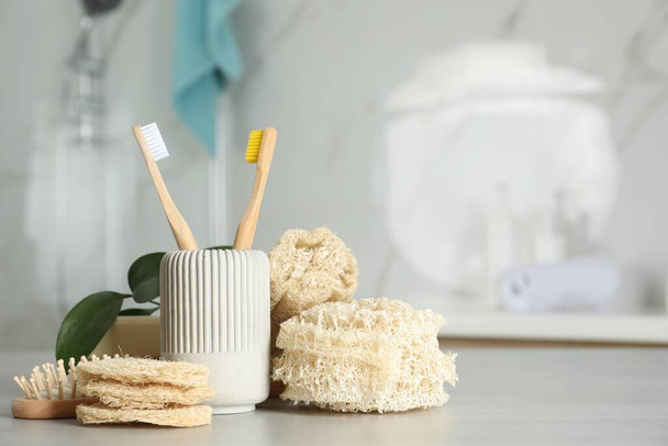 Composición con esponjas de esponja natural en la mesa en el baño. Espacio para texto - Foto, Imagen