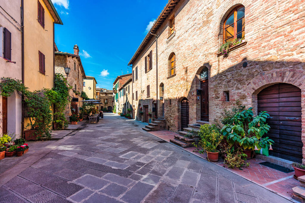 Cozy street decorated with colorful flowers, Pienza, Tuscany, Italy, Europe. Narrow street in the charming town of Pienza in Tuscany. Beautiful streets of the small and historic village Pienza, Italy - Foto, immagini