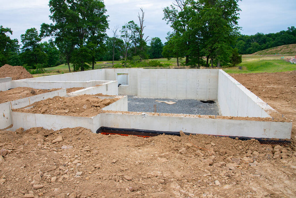Poured concrete foundation for new house construction in suburban neighborhood cement work - Valokuva, kuva