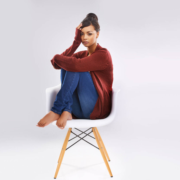 Свой стиль. Студийный портрет привлекательной молодой женщины, сидящей на стуле - Фото, изображение
