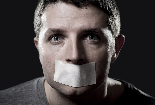 attraente giovane uomo con la bocca sigillata su nastro adesivo per impedirgli di parlare
 - Foto, immagini