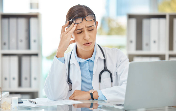 Headache stress, doctor burnout and sad nurse working on laptop in work office at hospital, tired from consulting in healthcare and anxiety from medical surgery. Worker with depression at clinic. - Valokuva, kuva