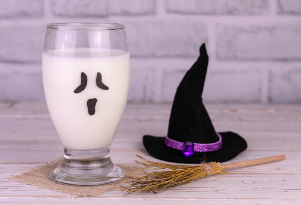 Milk in a glass with a scary face. The concept of children's drinks for Halloween. - Фото, зображення