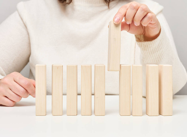 Wooden blocks on the table, a woman's hand holds one. The concept of finding unique, talented employees - Fotó, kép