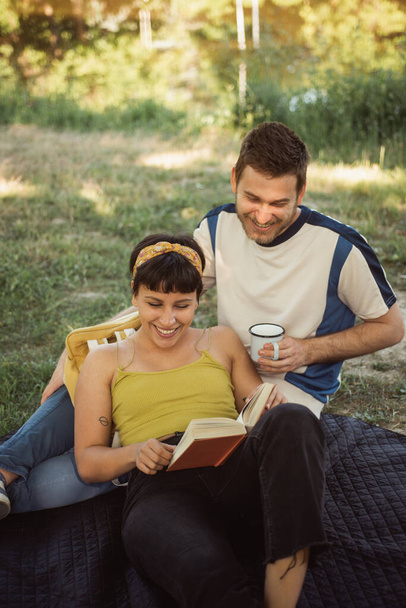 Geweldig koppel lezen samen in het park op de picknick - Foto, afbeelding