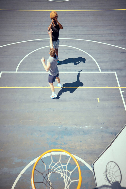 Basketball court players point score, team sports playing game and shooting in net with aim to win competition, match and action as community friends. Fitness skills, above and training outdoors. - Foto, immagini