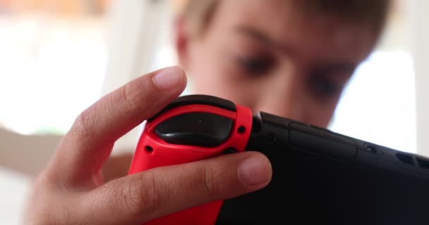Παιδί που παίζει βιντεοπαιχνίδι σε συσκευή τεχνολογίας. Κοντινό πλάνο του νεαρού αγοριού που κατέχουν gadget online παιχνίδι - Πλάνα, βίντεο