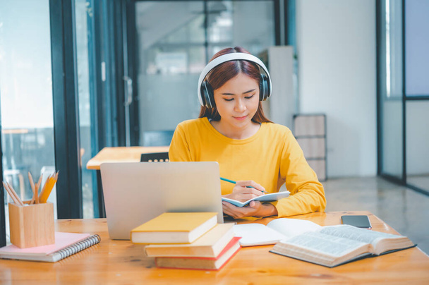 young student wearing headphones studies online, distance learning, and keeps up to date on the global coronavirus pandemic. - Foto, Imagem