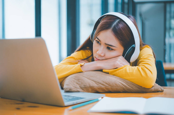 Female students are bored and sleepy during online classes while sitting online for long hours. - Photo, Image