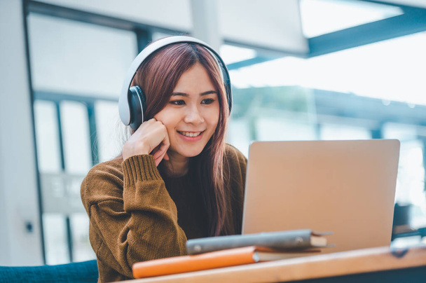young student wearing headphones studies online, distance learning, and keeps up to date on the global coronavirus pandemic. - Photo, image