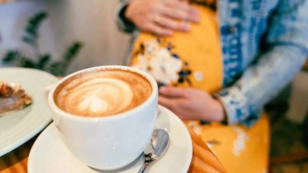 Pregnant woman coffee drink. Lifestyle morning with happy pregnancy girl drink espresso coffee. Represent breakfast, energy, freshness or great aroma concept - 写真・画像