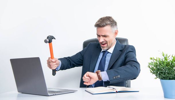 frustrated boss hitting laptop with hammer and checking time. - Foto, Imagem
