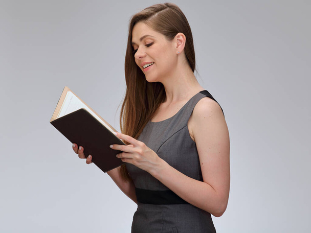 Profesor sonriente o estudiante mujer en vestido gris de negocios lee libro, retrato aislado. - Foto, Imagen