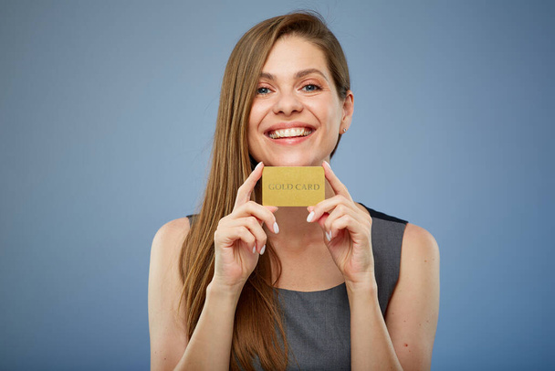Smiling woman holding gold credit card. isolated portrait. - Zdjęcie, obraz