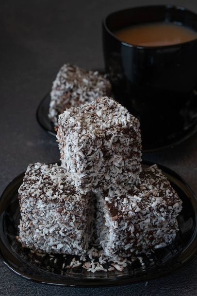 Chocolate Lamingtons on a Plate with Tea on a Table with Selective Focus - Photo, Image