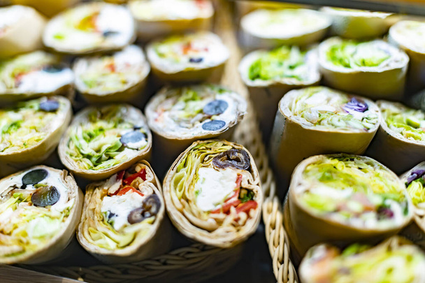 Freshly prepared tortilla wraps sold in a fast food restaurant. - Фото, изображение