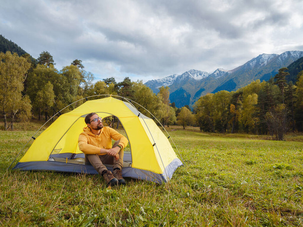 trip to Caucasus mountains, Arkhyz, Teberdinsky reserve. Man traveler relaxing in mountains in tent camping outdoor Travel adventure lifestyle concept hiking active vacations. - Foto, afbeelding