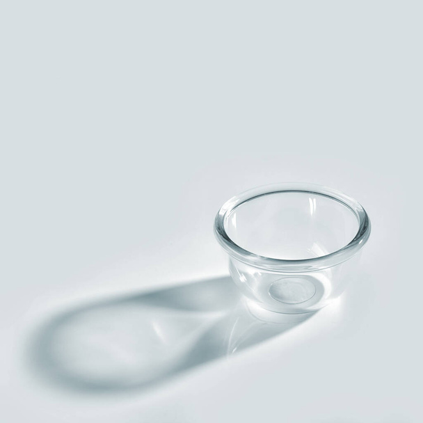 empty glass bowl with long shadow on white background - Fotó, kép