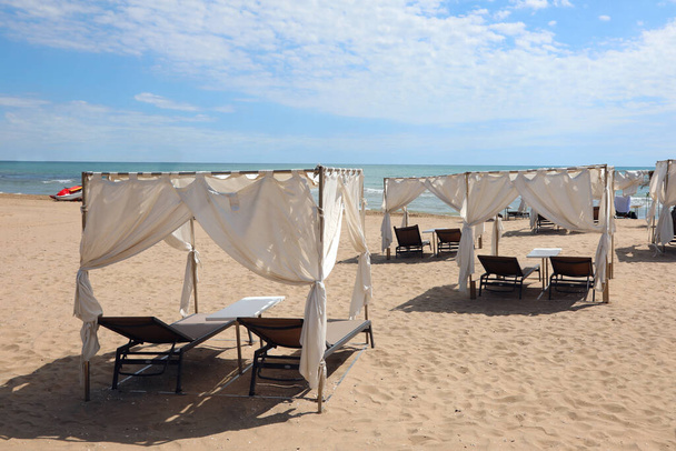 gazebos to shelter from the sun with deckchairs in the exclusive resort by the sea in summer without people - Photo, image