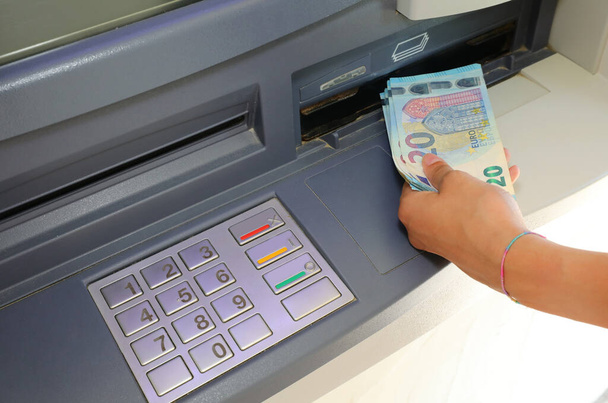 hand of the person who withdraws money in european twenty euro banknotes in the atm automatic teller machine - Foto, Imagem