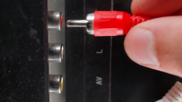 Hand inserts rca connectors of red white and yellow color from tv. Plug tulip of the old generation close-up. Wires for transmitting audio and video signals are thin, poor quality. High quality 4k - Filmmaterial, Video