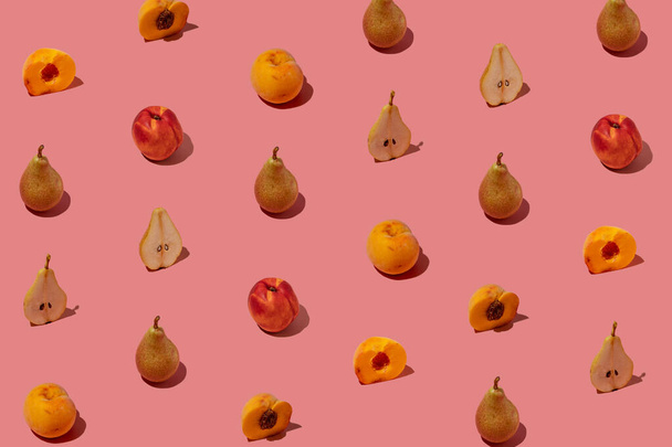 Kreatywny wzór wykonany ze świeżych gruszek i brzoskwiń na pastelowym różowym tle. Minimalny letni układ owoców. - Zdjęcie, obraz
