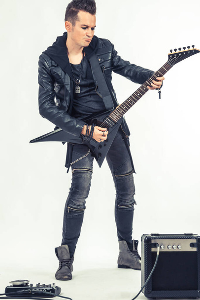 Πλήρες μήκος του hard rock μουσικός παίζει ηλεκτρική κιθάρα σε λευκό φόντο.  - Φωτογραφία, εικόνα